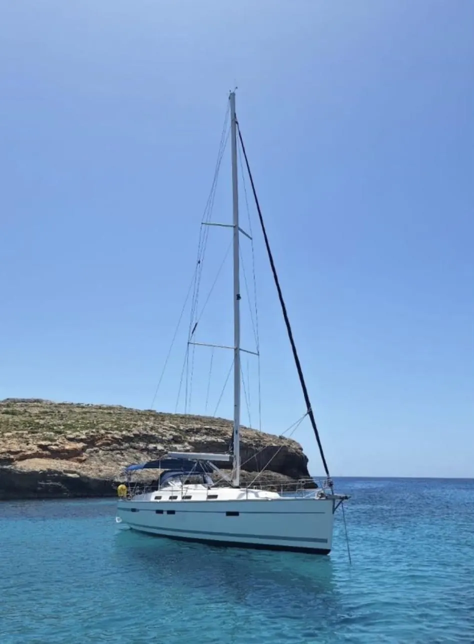 Bavaria Cruiser 45 sailing yacht at anchor below limestone cliffs